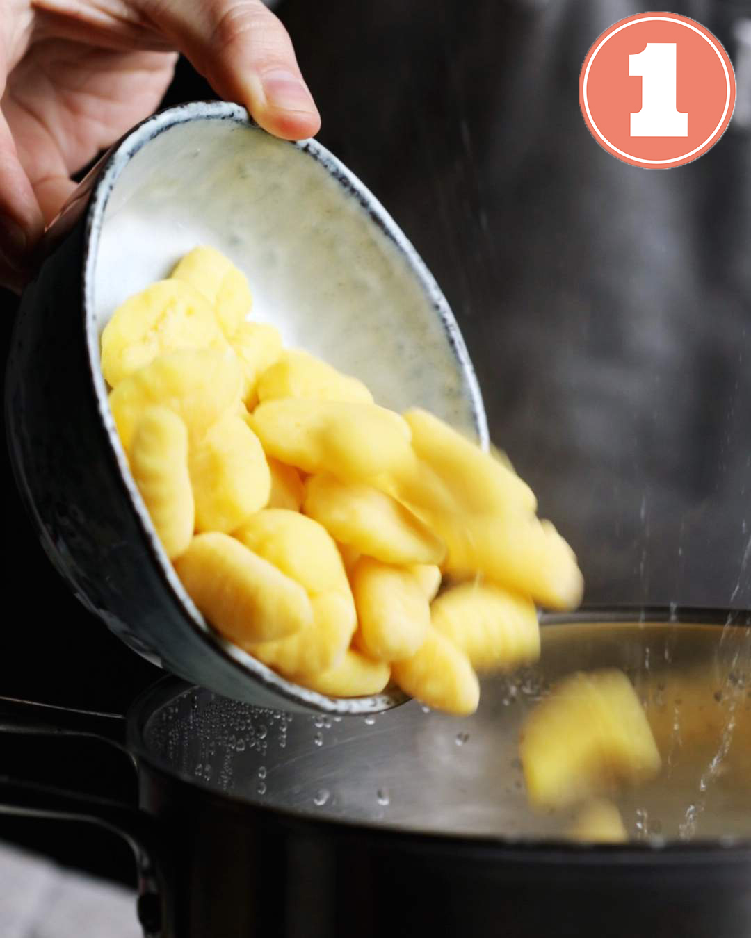 Adding gnocchi into boiling hot water.