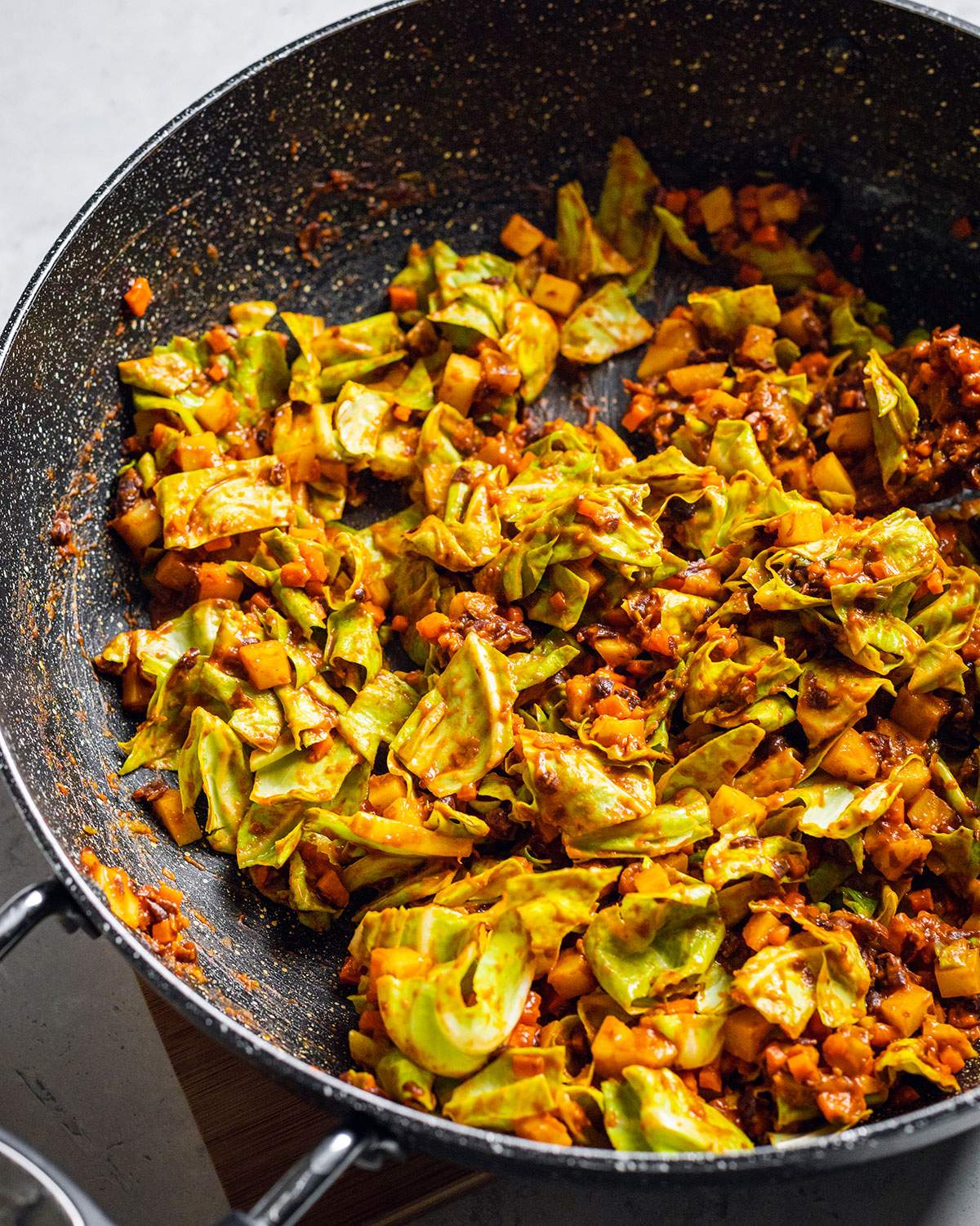 Plant-based Black Bean sauce with green cabbage in a large wok.