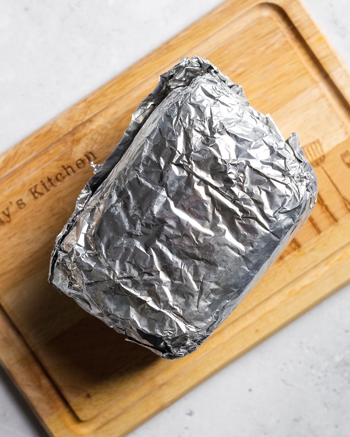 A block of vegan pork belly wrapped firmly in aluminum foil.