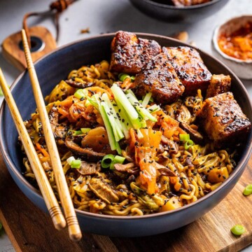 A bowl filled with vegan black bean ramen on the dinner table with chopsticks on the side.