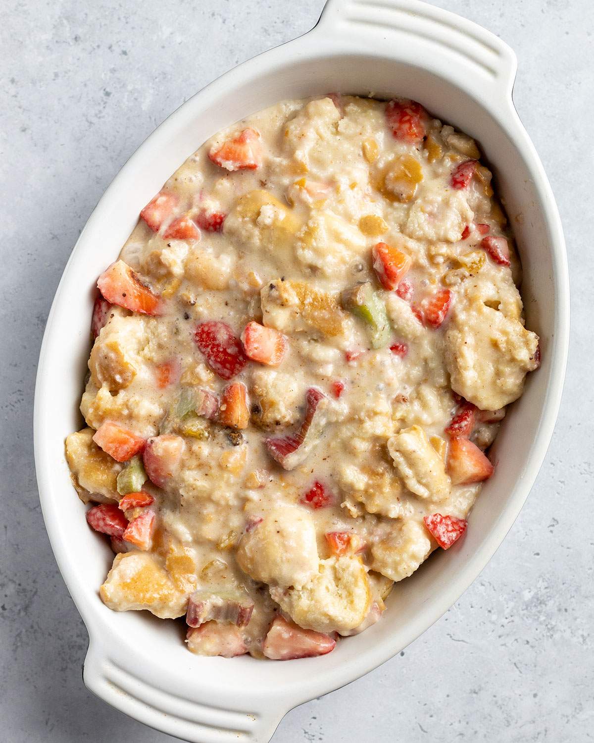 Vegan bread pudding mix in an oval oven dish before baking.