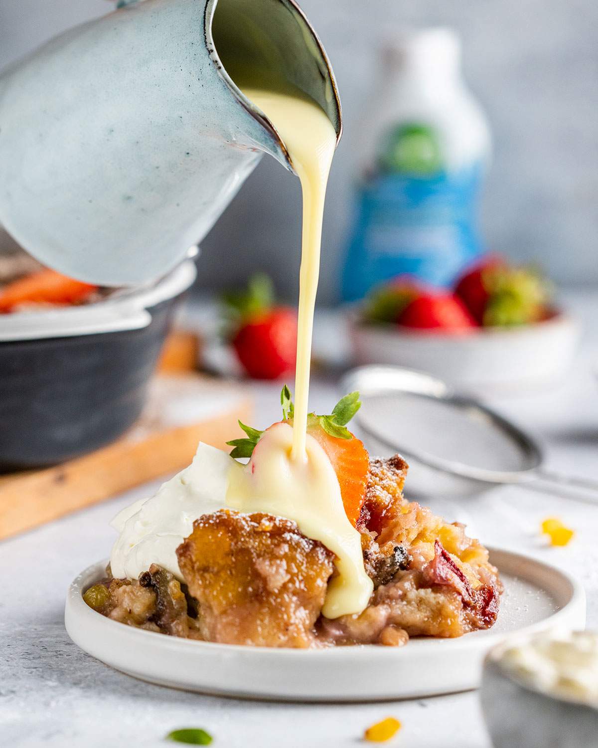 Pouring vegan custard onto a serving of vegan bread pudding.