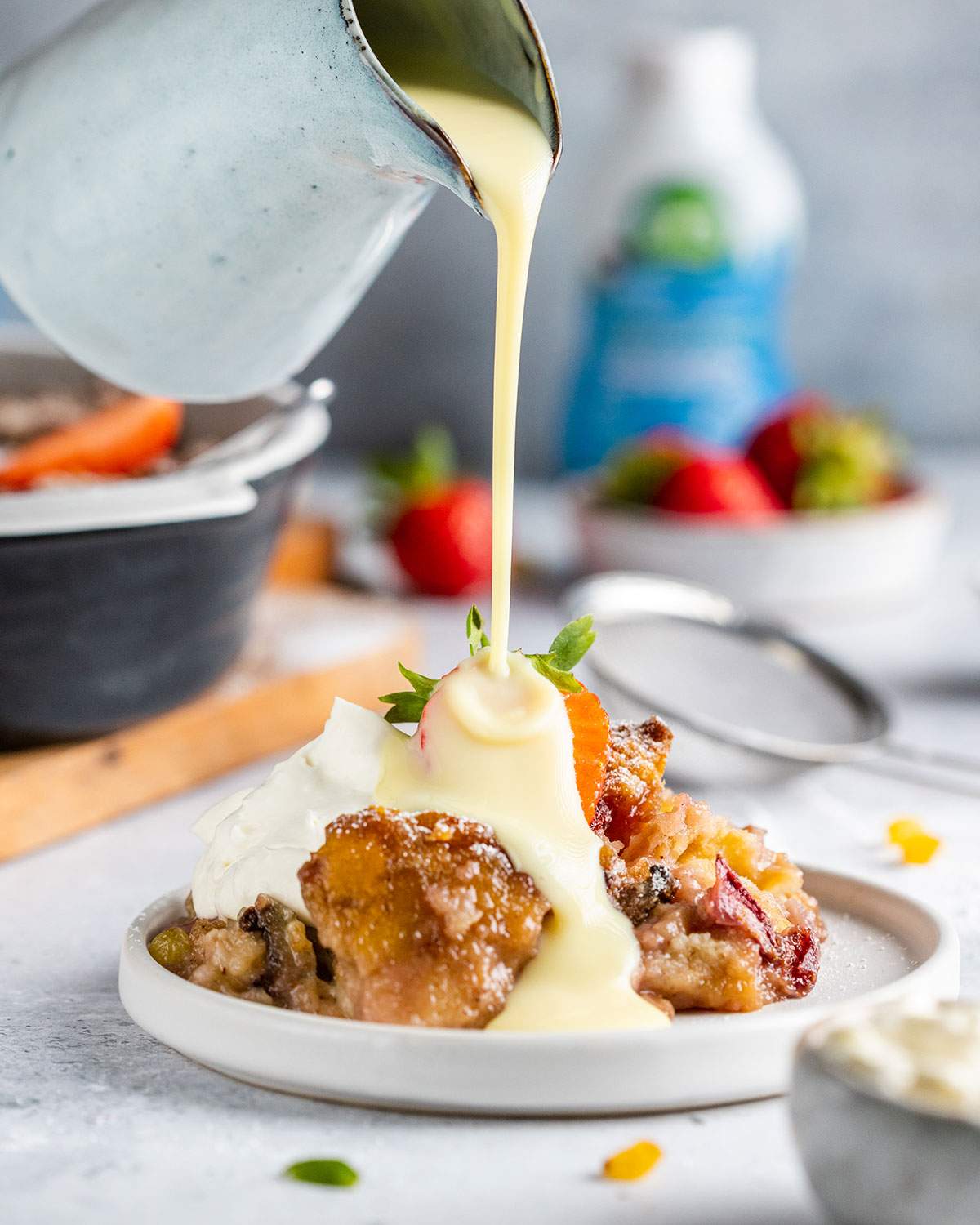 Pouring vegan custard onto a serving of vegan bread pudding.