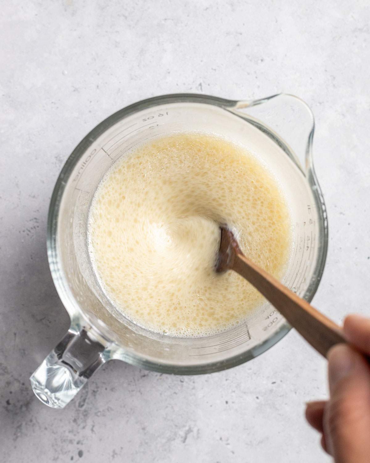 The wet ingredients for vegan Kaiserschmarrn are stirred in a glass jug.