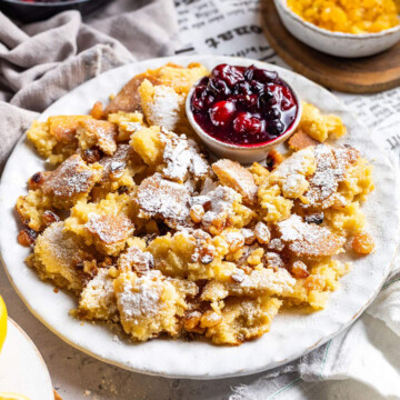 A square image of vegan kaiserschmarrn with cherries on a white plate.