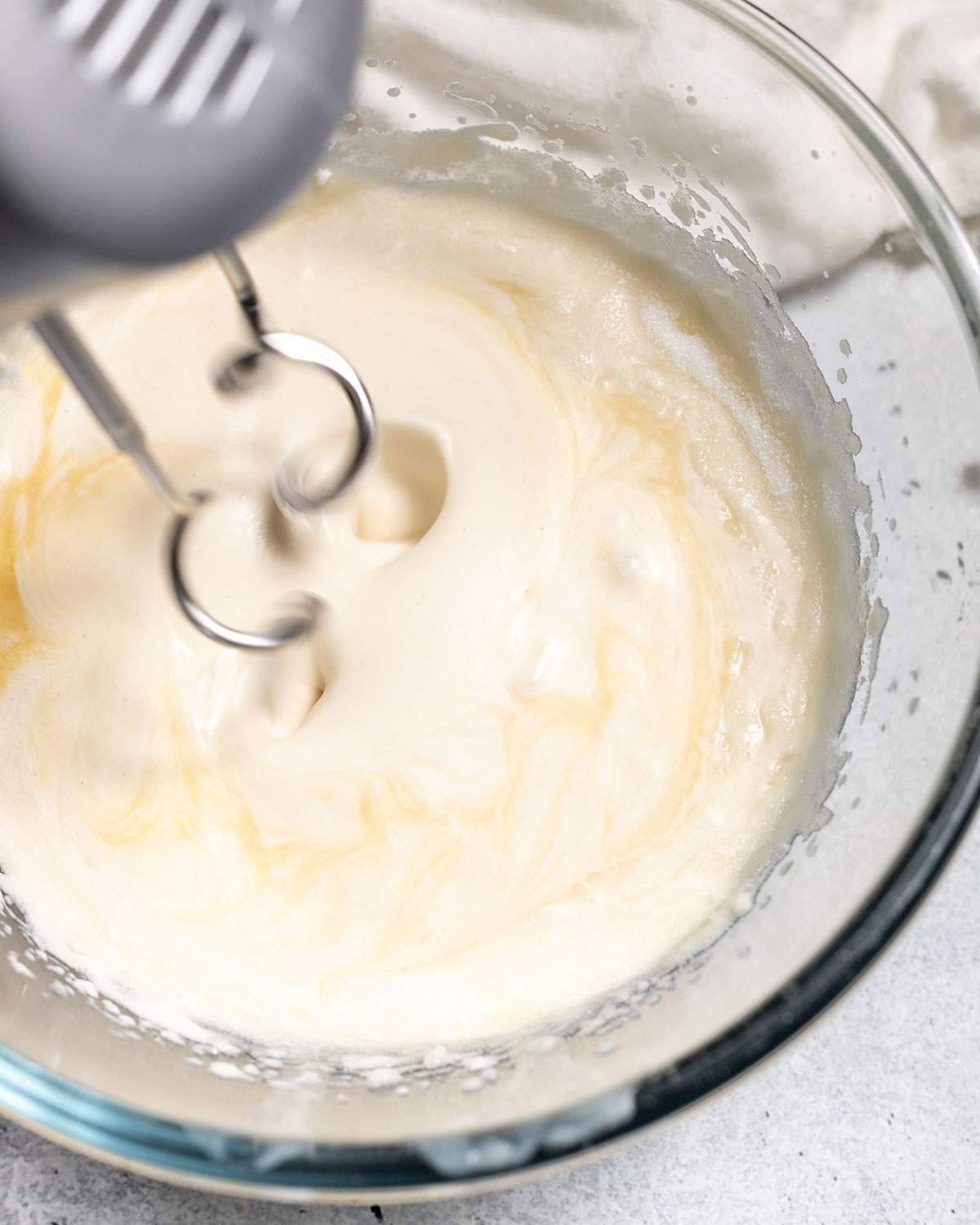 An electric mixer blending all ingredients for the vegan cheesecake.