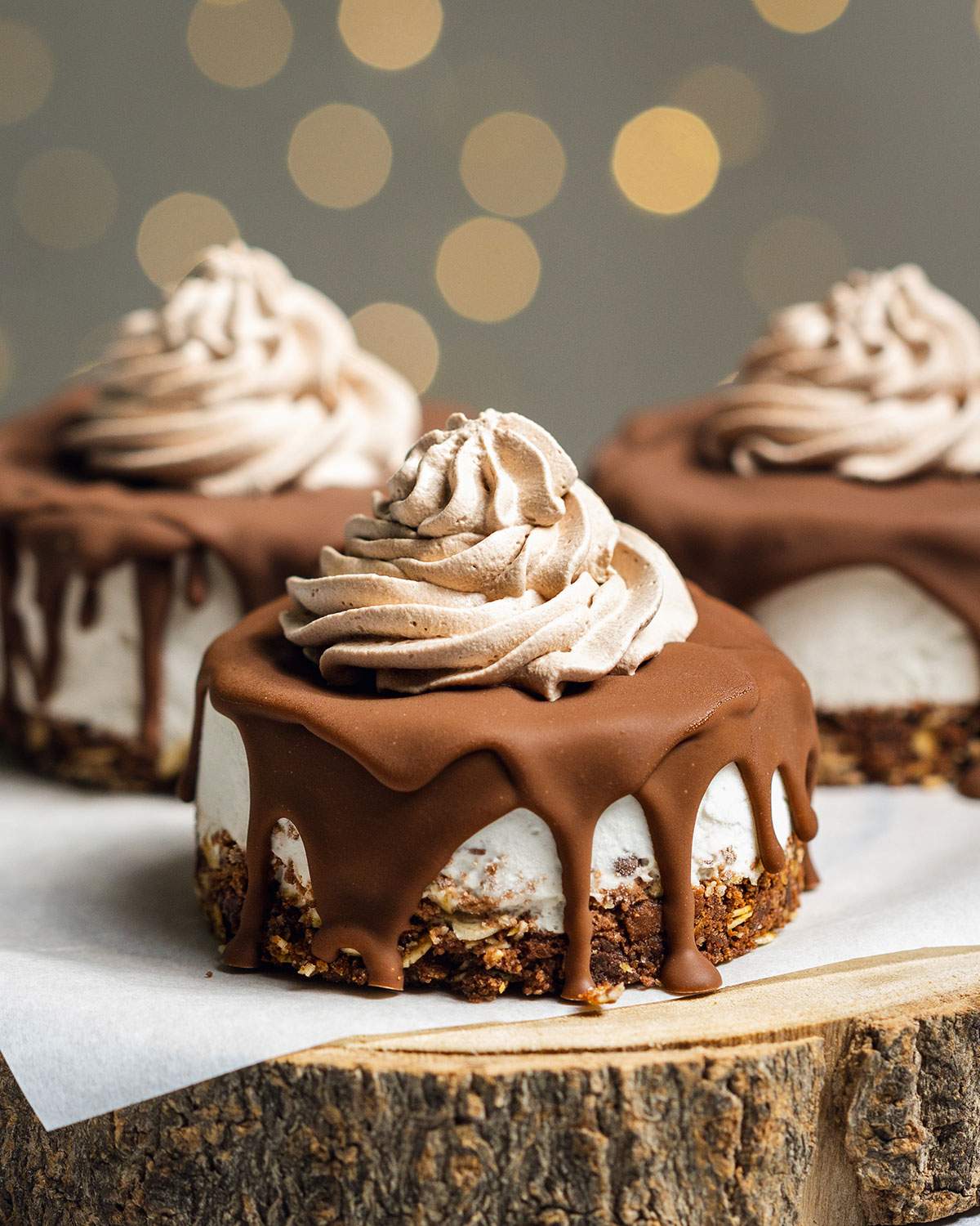 Three vegan mini cheesecake bites with chocolate on top on a serving platter.