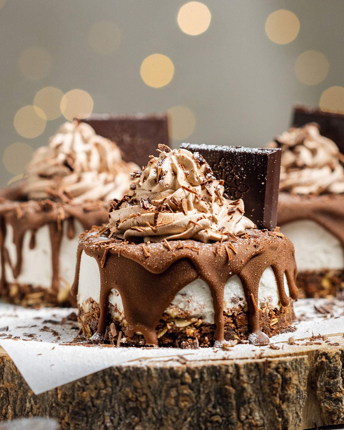 Three vegan mini cheesecake bites with chocolate on top on a serving platter.