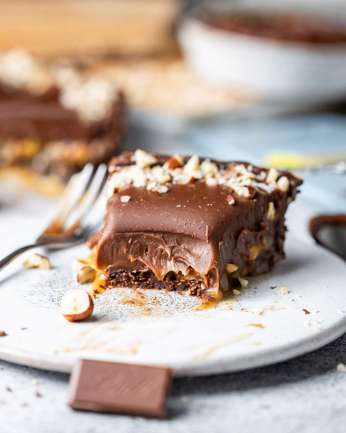 A slice of half-eaten decadent chocolate tart on a dessert plate.