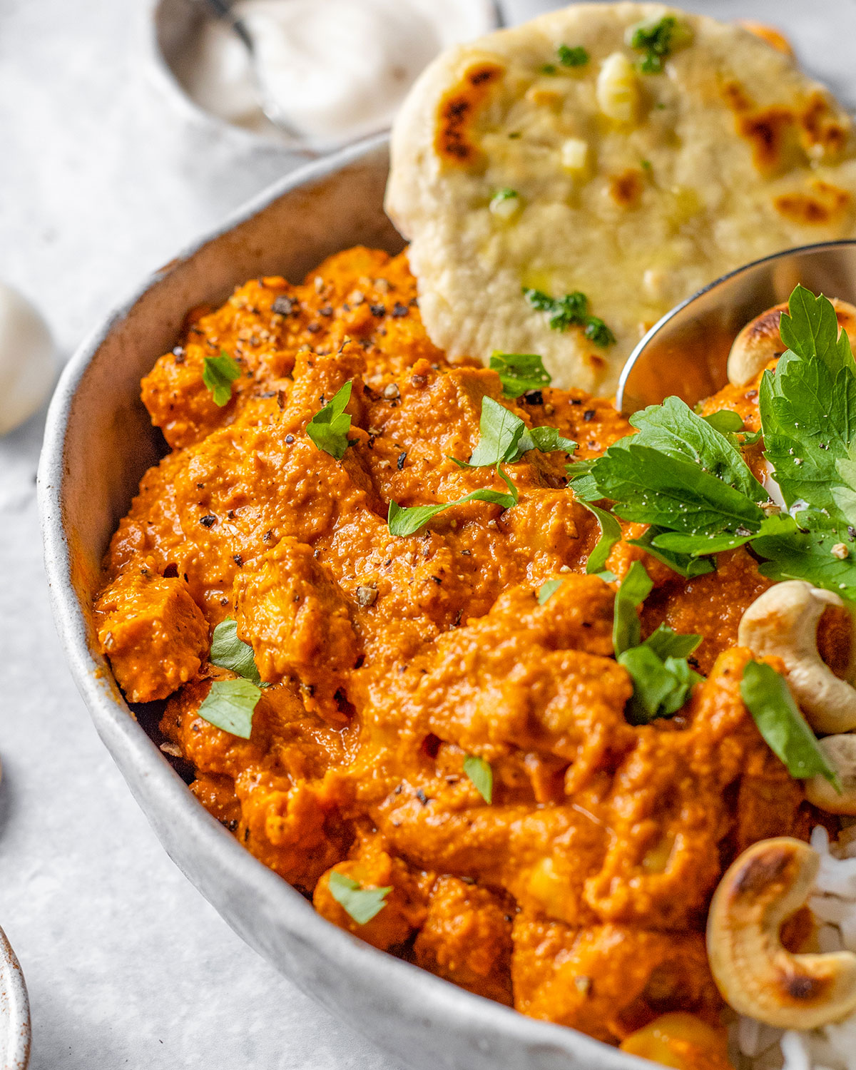 Vegan tikka masala sauce shown close up with fresh cilantro on top. 