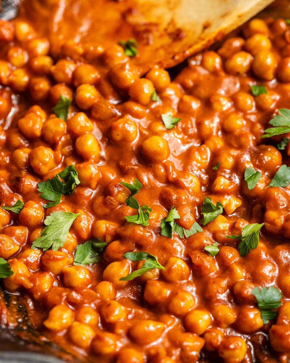 Creamy buffalo chickpeas in a skillet seen up close.