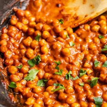 Chickpeas in vegan buffalo sauce in a skillet.