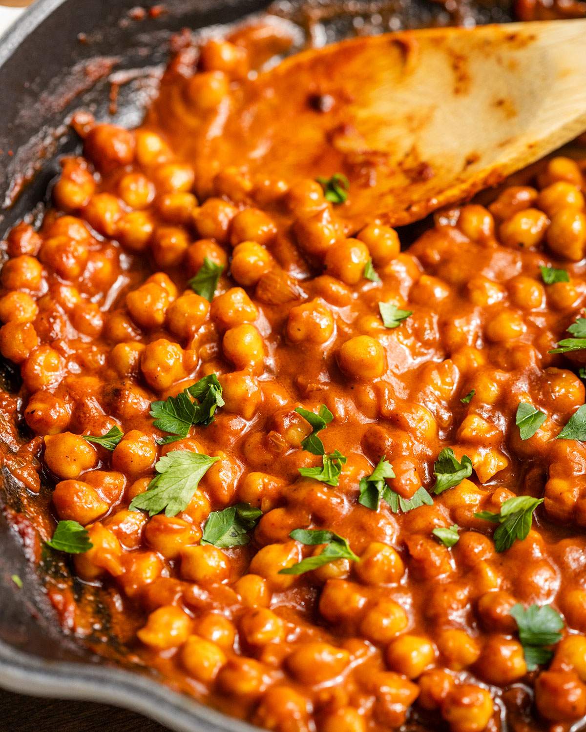 Chickpeas in vegan buffalo sauce in a skillet.