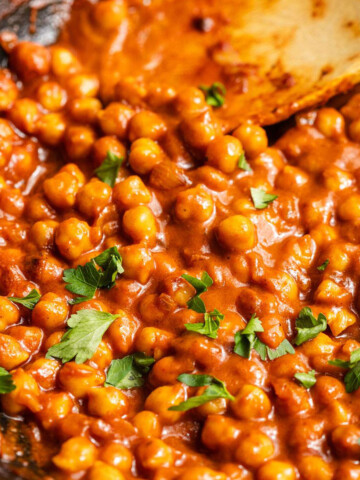 Chickpeas in vegan buffalo sauce in a skillet.