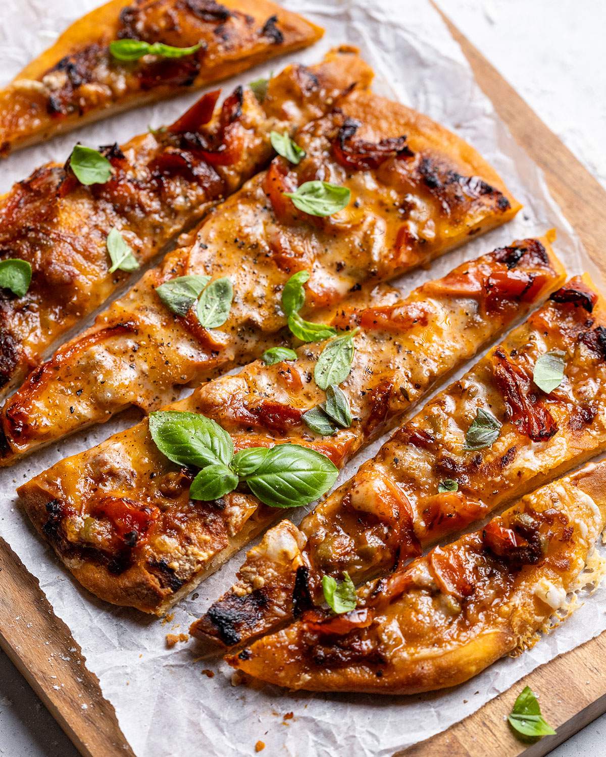 Vegan air fryer pizza sliced on a serving board.