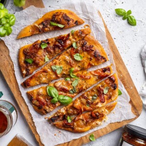 Sliced air fryer flatbread pizza on a serving board.