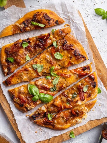 Sliced air fryer flatbread pizza on a serving board.