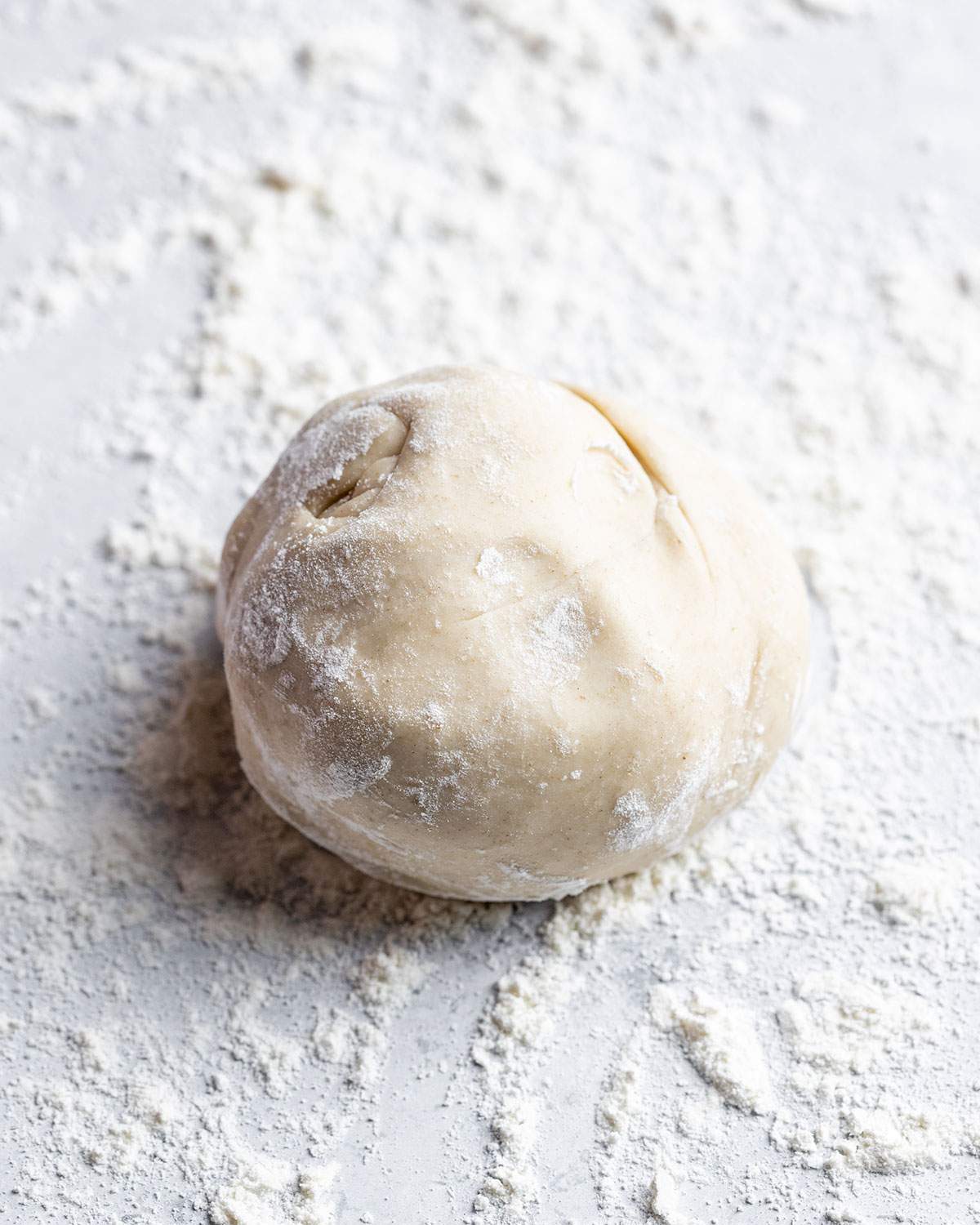 Flatbread dough ball on a floured surface.