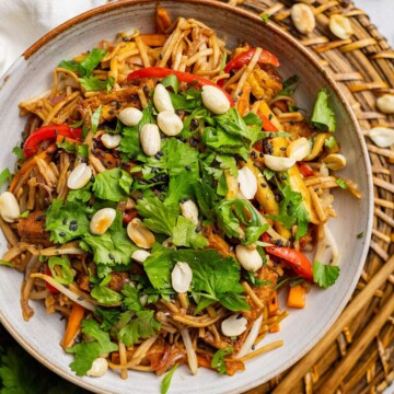 Healthy pad thai served in a bowl and garnished with peanuts and fresh coriander.
