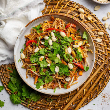 A bowl of healthy pad thai on a serving mat.