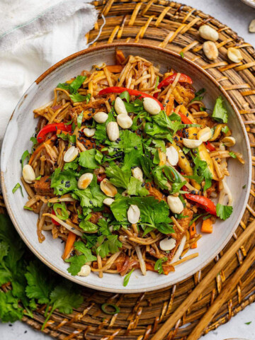 A bowl of healthy pad thai on a serving mat.