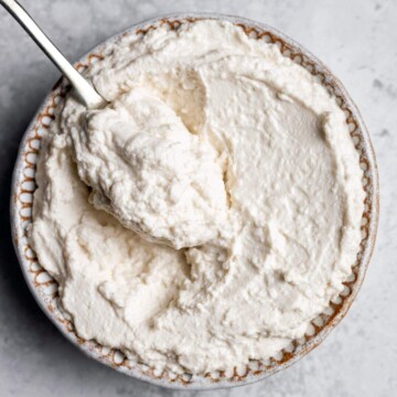 A bowl full of vegan almond ricotta with a spoon.