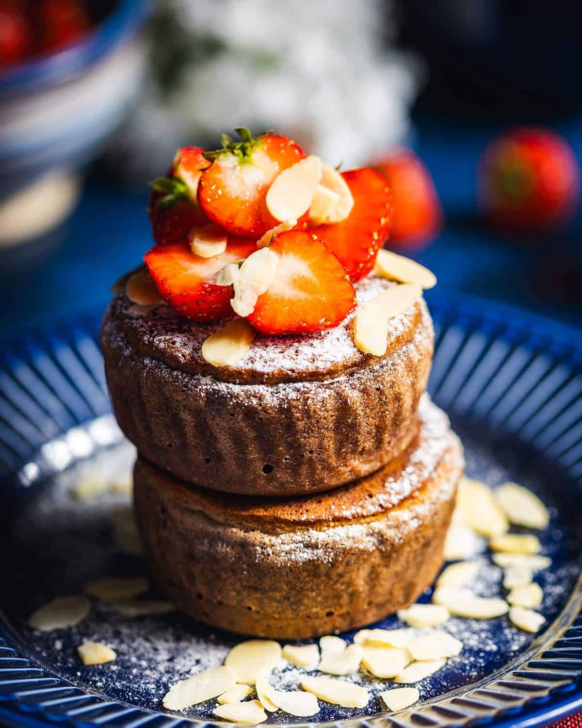 Two vegan protein soufflé pancakes stacked on a plate with strawberries.