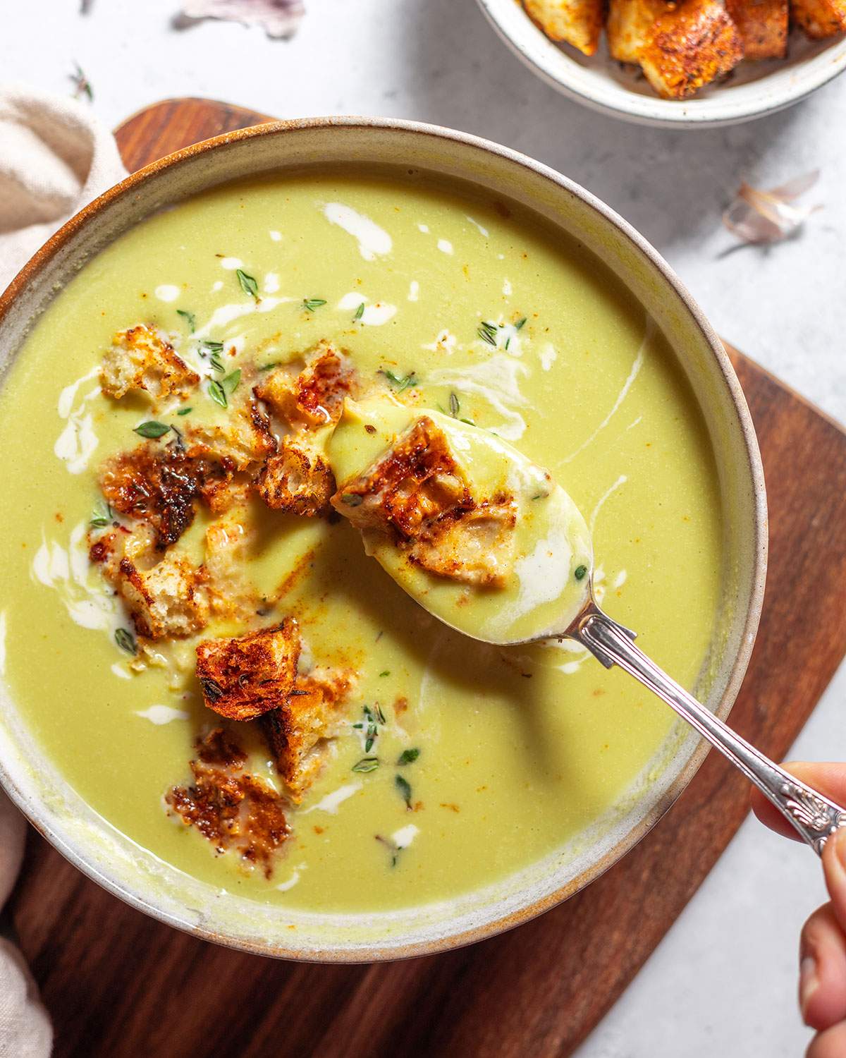 Spooning asparagus soup from a big soup bowl.