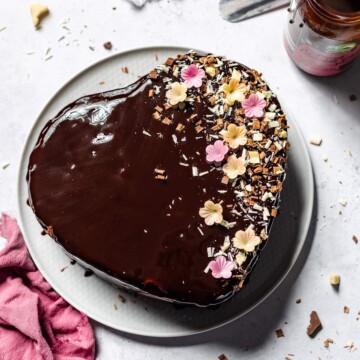 A heart shaped avocado chocolate cake on a serving platter.