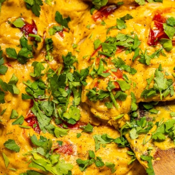 A close up of a creamy orzo dish with fresh herbs in a skillet.