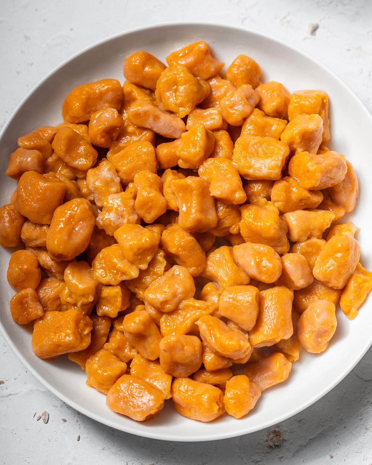 A plate filled with homemade sweet potato gnocchi.