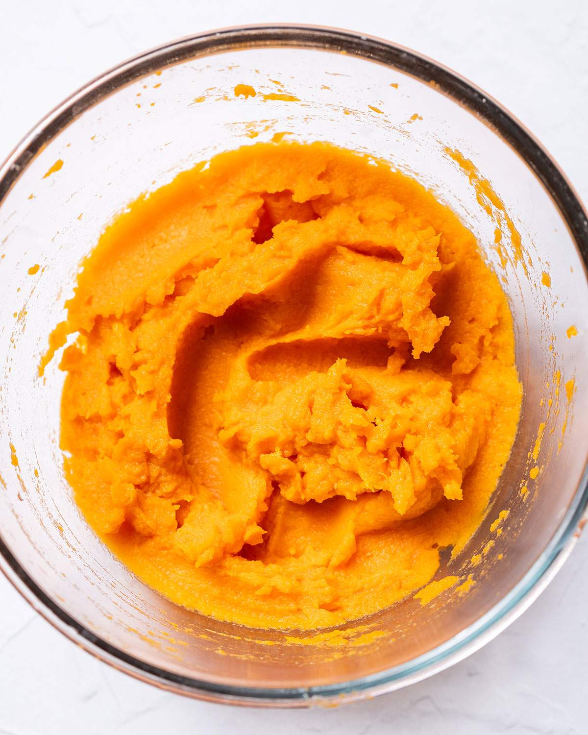 Mashed sweet potato in a  glass bowl.