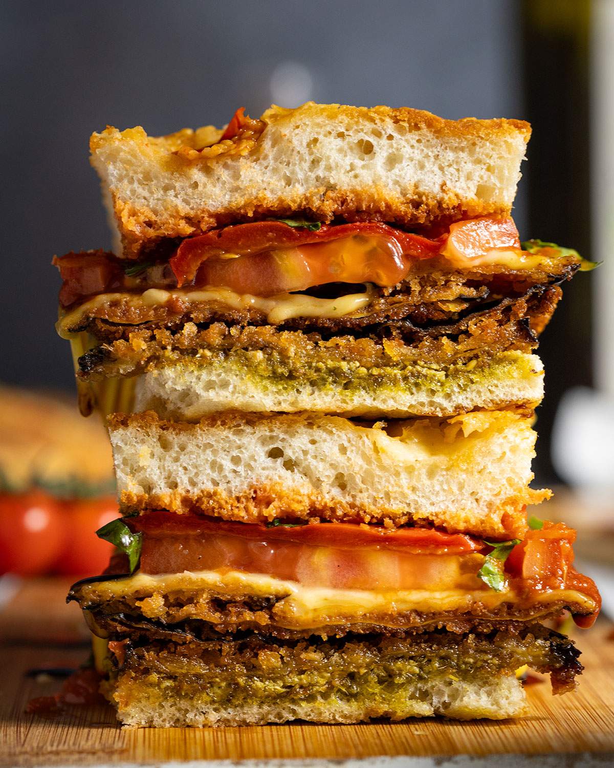 Two stacked slices of an eggplant parmigiana focaccia sandwich with all sandwich layers visible.