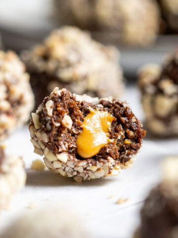 Half a vegan snickers protein ball with a smooth peanut butter filling oozing from the centre.