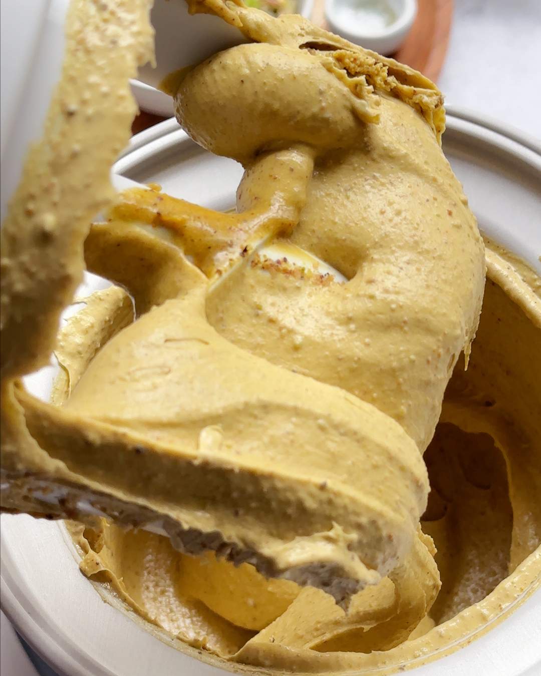 Soft churned ice cream coming out of an ice cream maker.