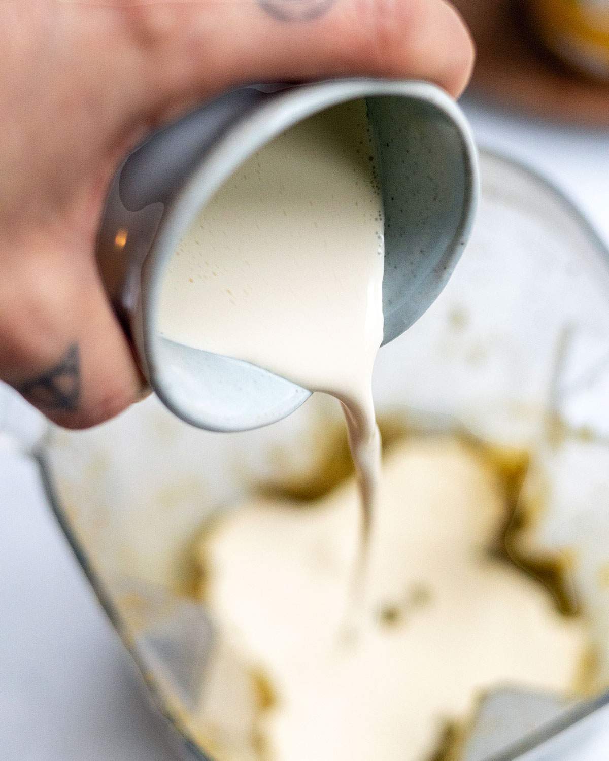 Pouring vegan heavy cream into a blender.