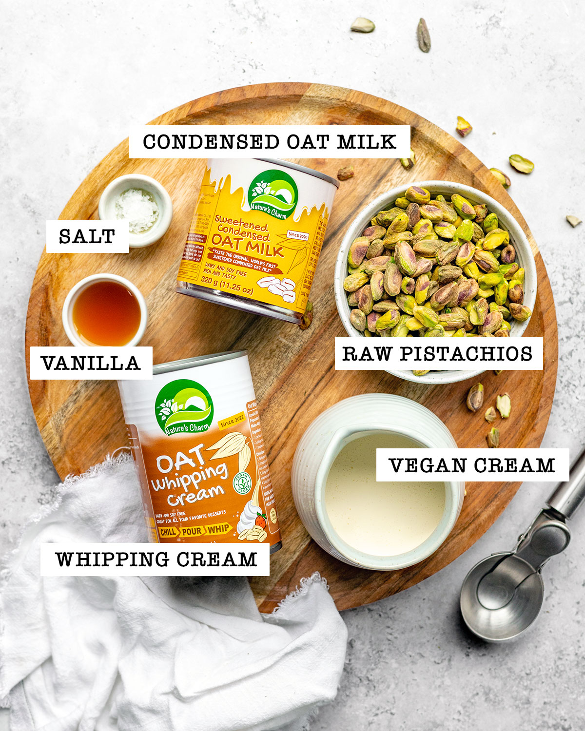 Ingredients for vegan pistachio ice cream on a board with labels.