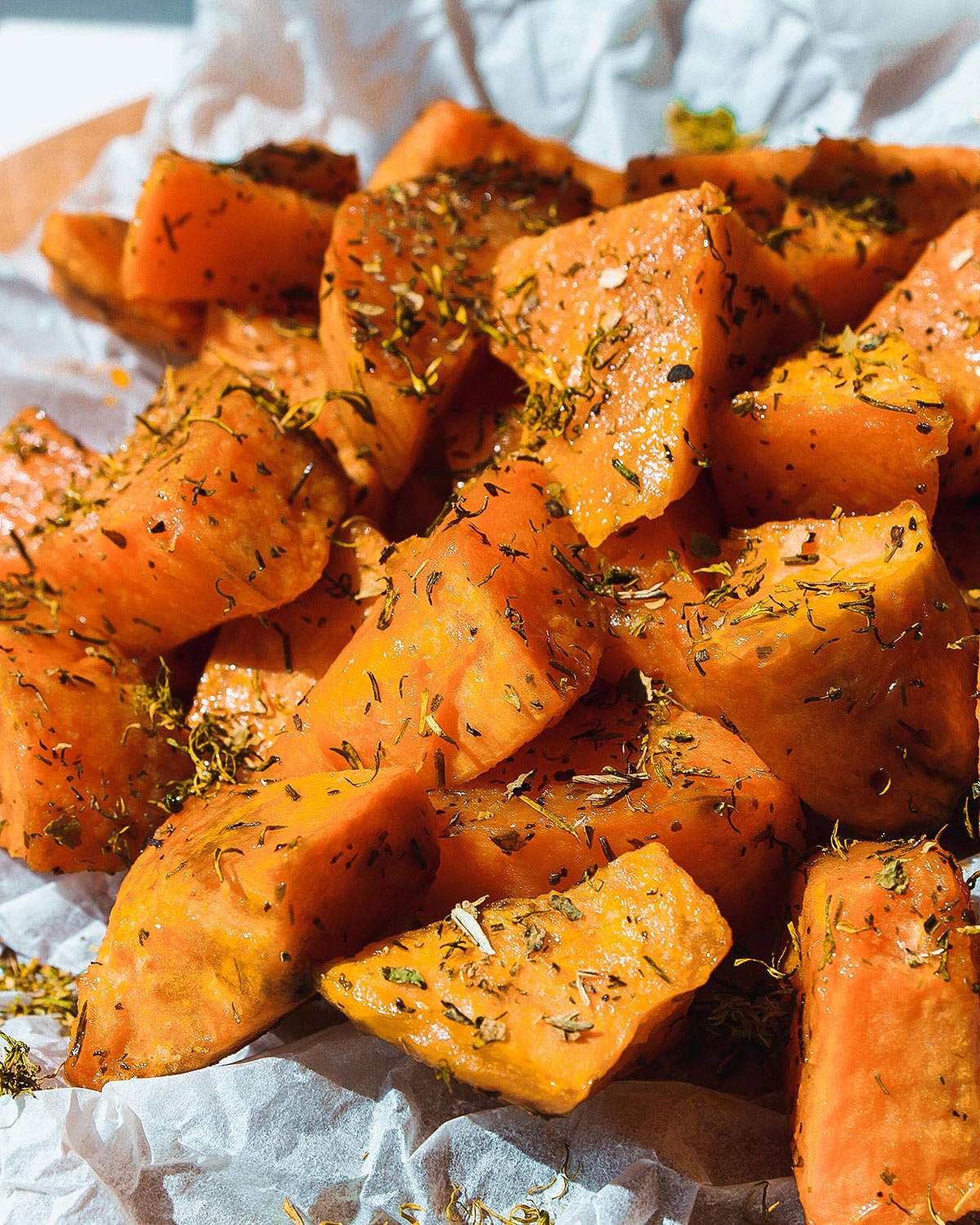 Roasted Seasoned Sweet Potato Cubes on parchment paper.