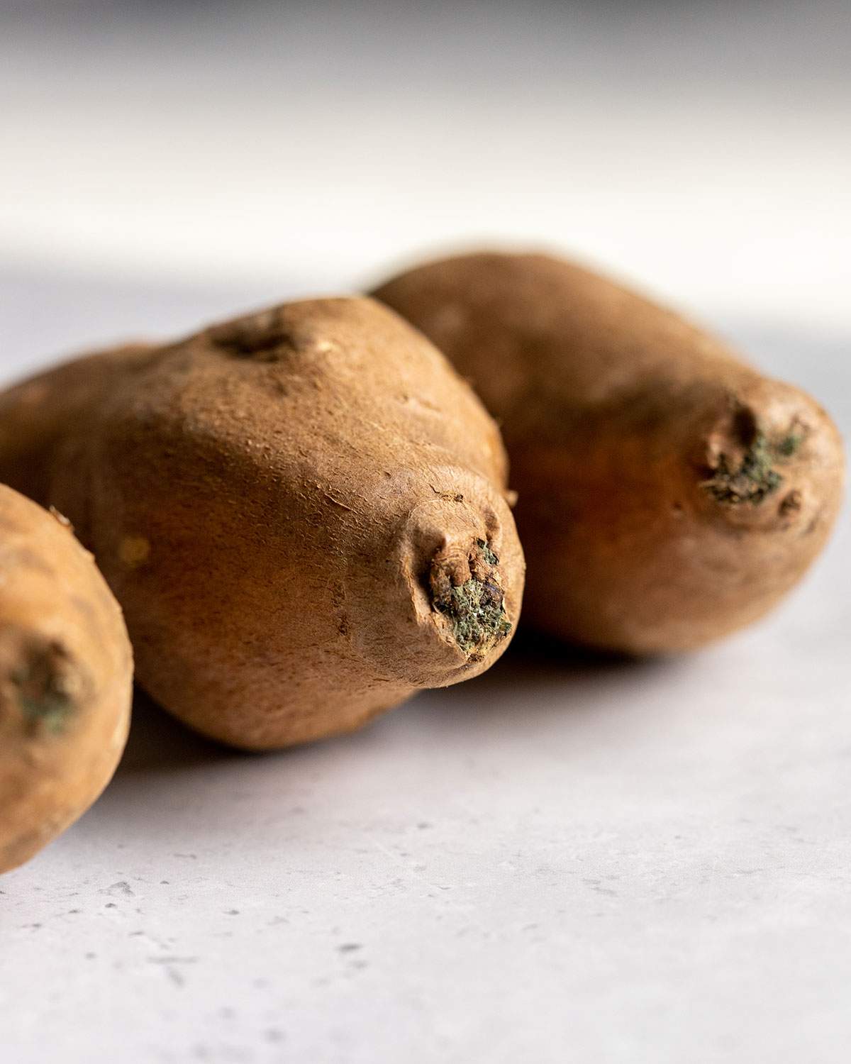 Mouldy and soft edges of 3 sweet potatoes.