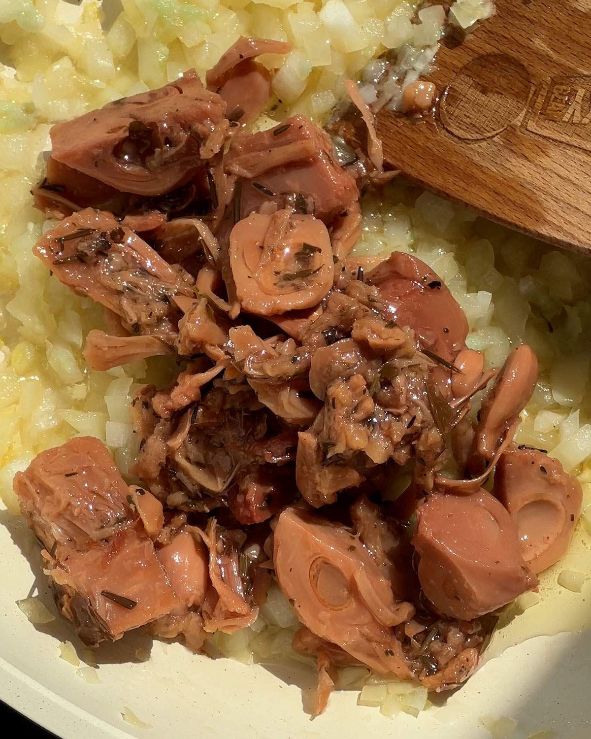 Jackfruit added to onions in skillet.
