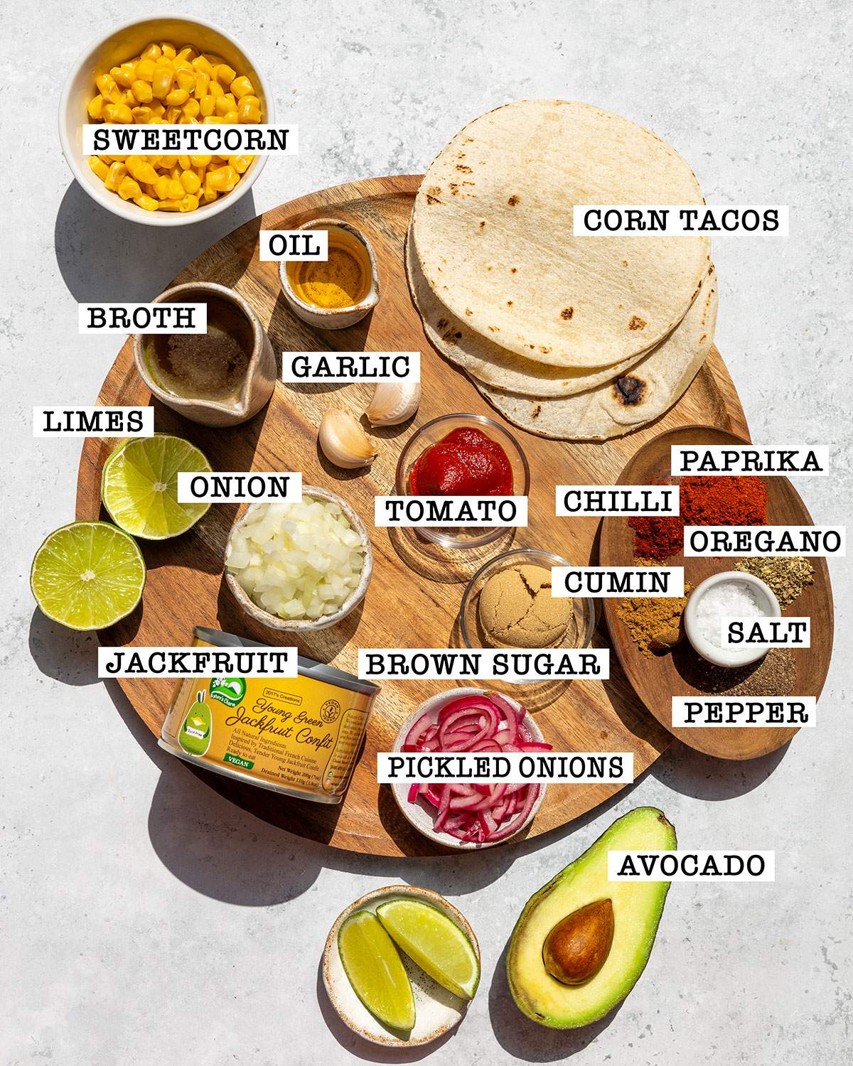Ingredients for jackfruit carnitas tacos on a platter with labels next to each ingredient.