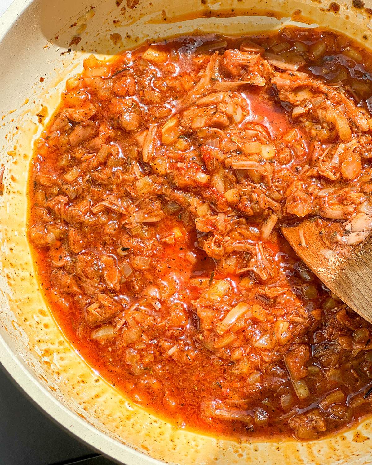 Jackfruit, sauce and seasonings cooking in a skillet.
