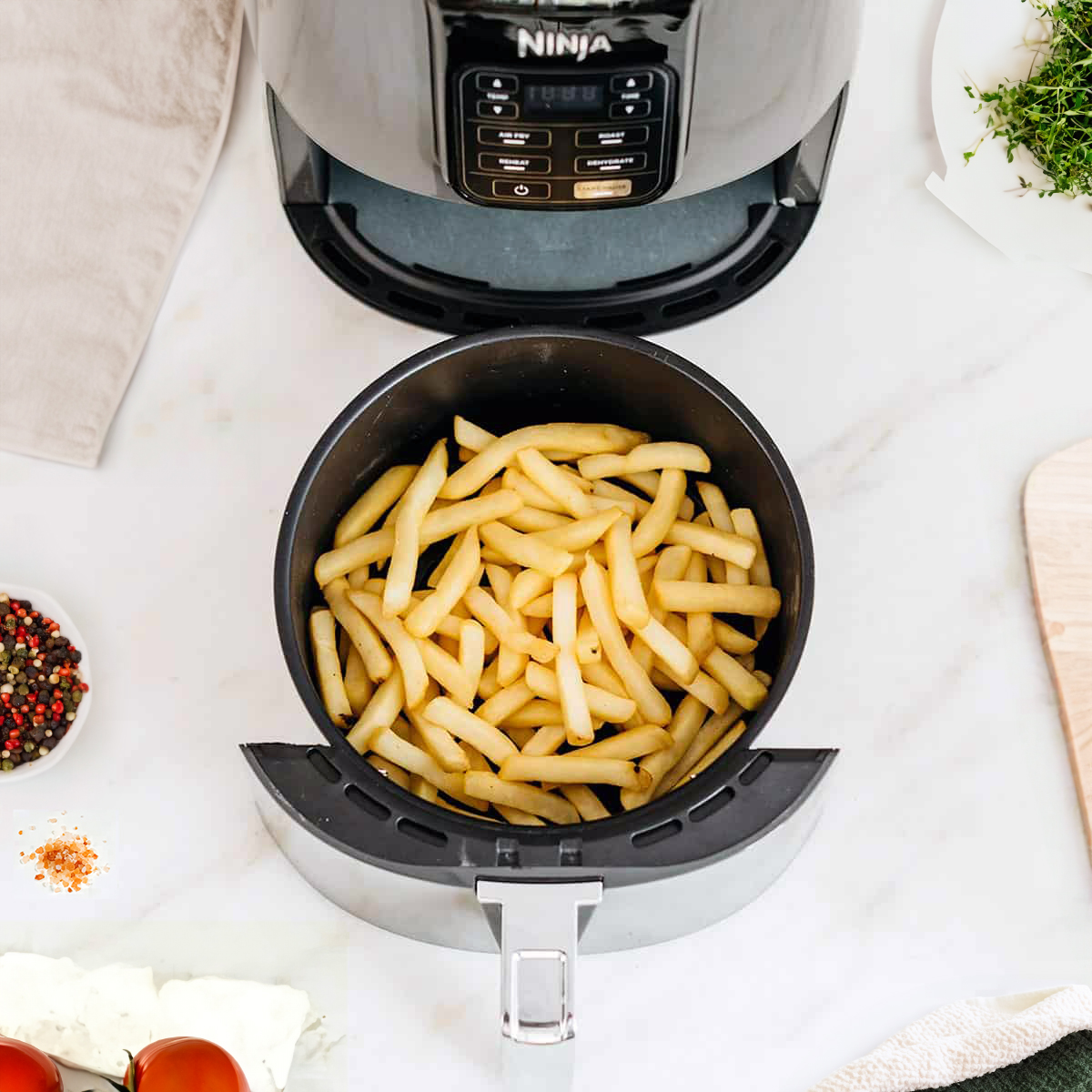 Fries inside of an air fryer basket.