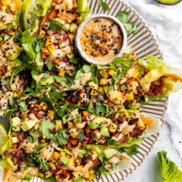 Spicy jackfruit lettuce wraps drizzled with tangy peanut sauce on a serving platter.