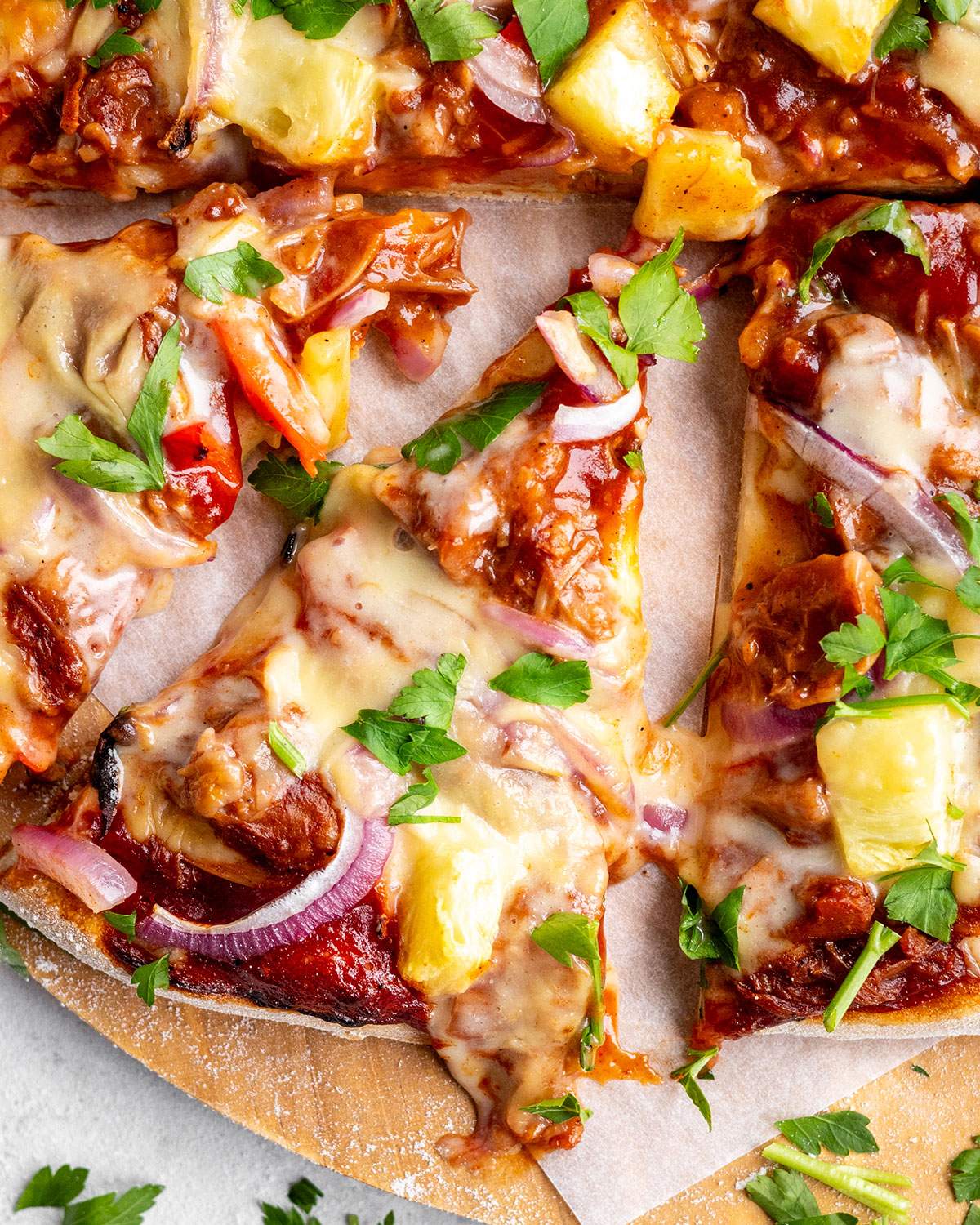 A slice of cheesy vegan pizza on a serving platter.