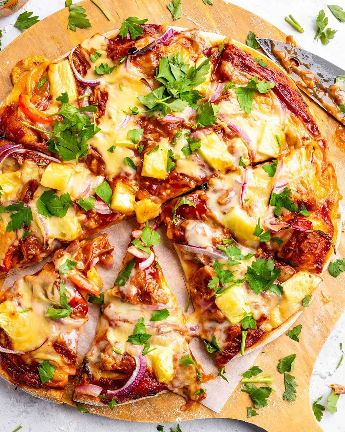Sliced BBQ pizza on a serving board.