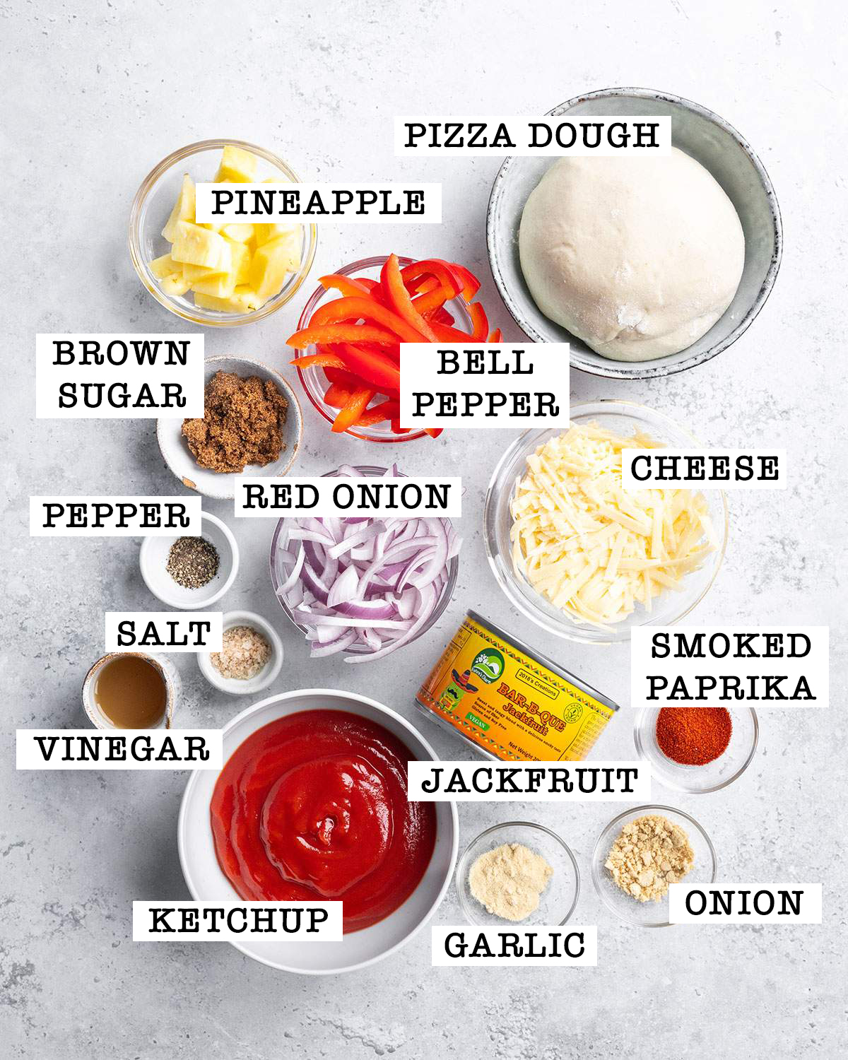 Ingredients for Vegan BBQ Pizza on a white table.