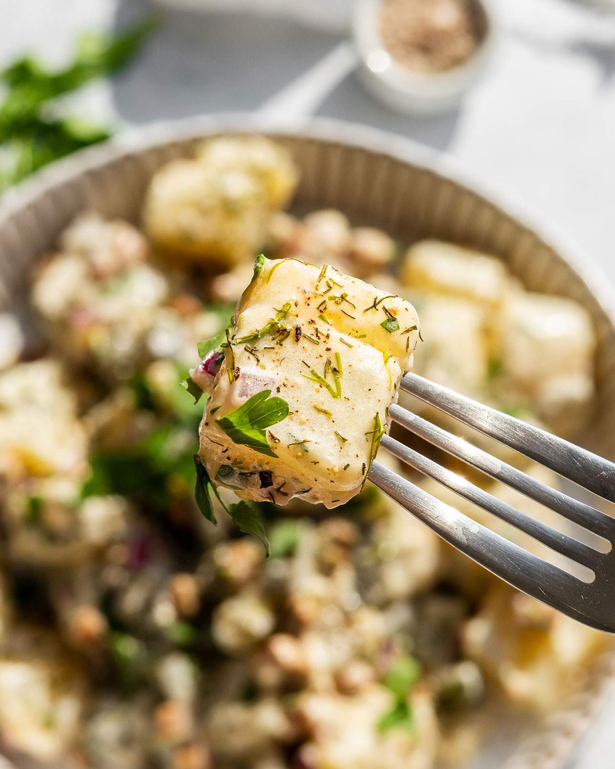 A fork lifting a piece of german potato salad.