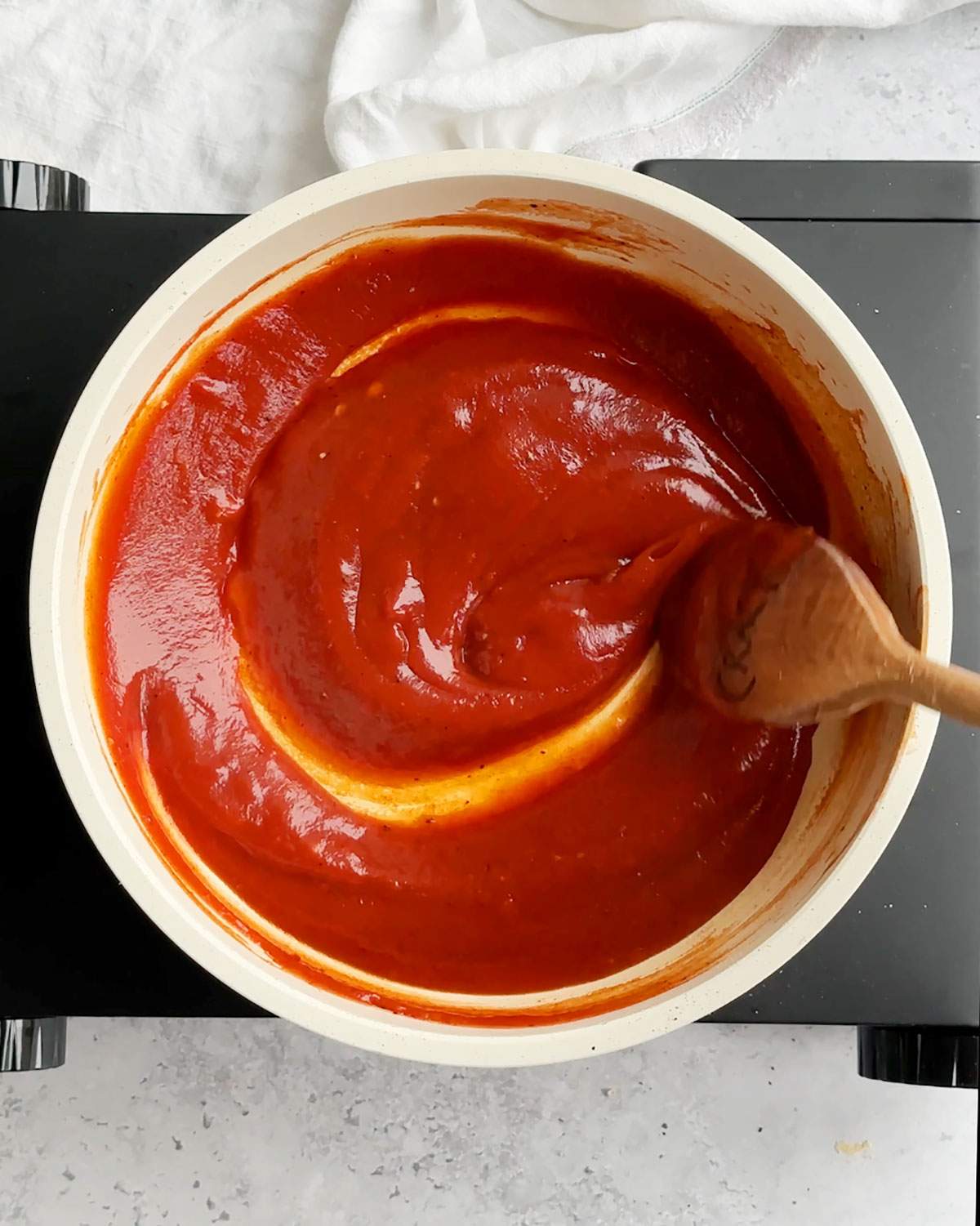 Stirring vegan bbq sauce in a pan.