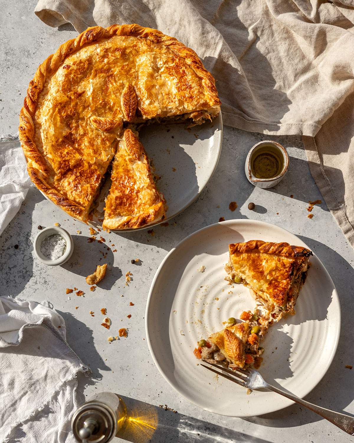 Vegan Chicken Pot Pie on the table with a slice of the pie on a small plate next to it.